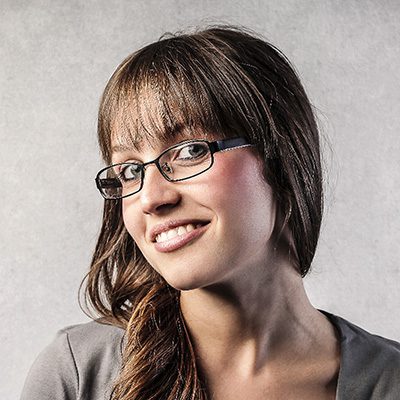 A woman with long hair and glasses smiling.